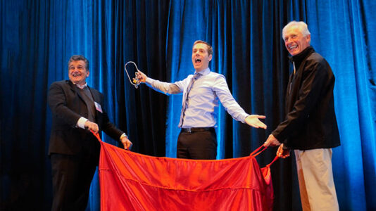 Joe Skilton escapes from handcuffs on stage at a sales kickoff.